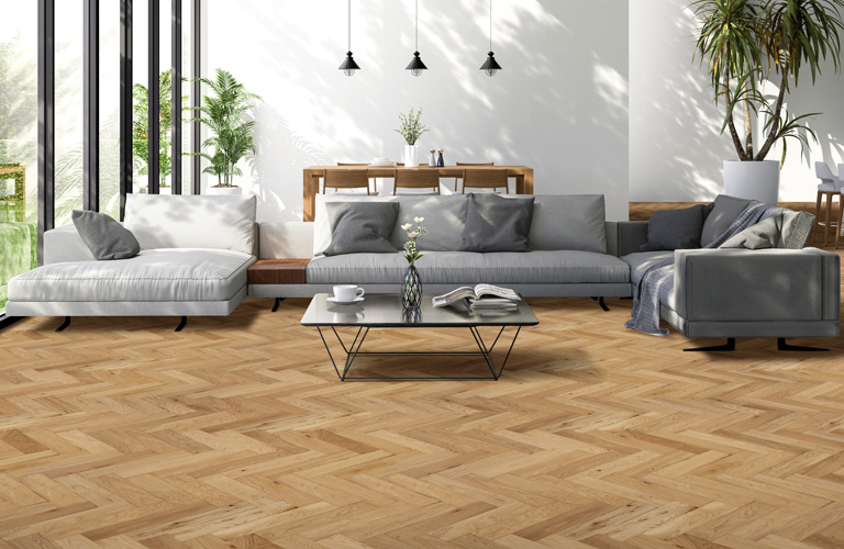 wooden herringbone floor with grey sofa